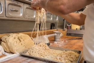 cook hand making pasta; click image to view gallery of pasta making photos